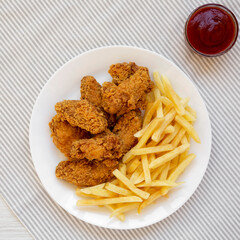 Homemade Crispy Chicken Wings and French Fries with ketchup, overhead view. Top view, from above, flat lay.