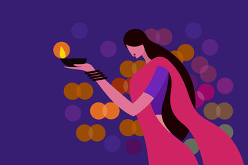 A woman wearing traditional dress holding Diwali festival lamps in her hand