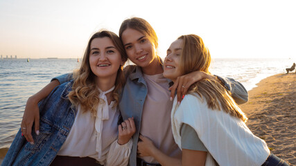 Three friends are walking on the beach, the happiness of communication.