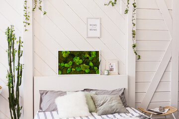 Interior light wall with a picture of moss, white walls, plants, candles and frames , bed , home and comfort