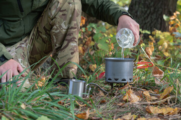 The pot is on the gas burner, the water is boiling. Autumn view