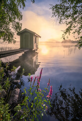 Beautiful morning landscape with little swim cottage, pier and foggy sunrise in lakeside Finland - 389161055