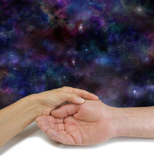 Obraz na płótnie Canvas Palm Reading Cosmic Message Background - female hand holding man's open hand against a deep space night sky background with copy space for messages above 