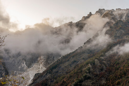 View of the Cervaiole marble quarry at sunset, shrouded in fog and low clouds, Seravezza, Apuan Alps, Italy