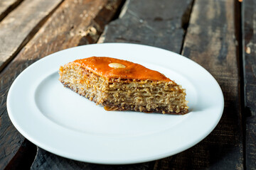 Traditional arabic dessert baklava with cashews, walnuts and cardamom with eucalyptus branch on a wooden table.....