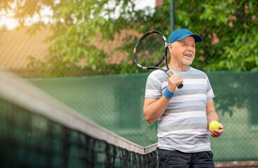 Fototapeta Smiling, sporting, active senior man playing tennis in the outdoor, sports pensioner, sport concept obraz