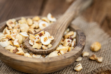 Portion of freshly chopped Hazelnuts (close up; selective focus)