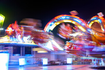 Fototapeta na wymiar Amusement park blurred effect. Abstract illuminated background