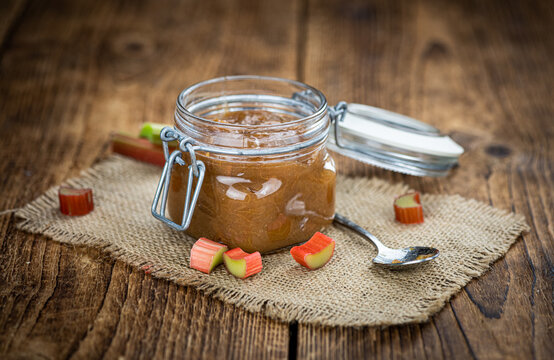 Rhubarb Jam on an old wooden table (close up shot; selective focus)