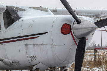 Fototapeta na wymiar small aircraft with a propeller at the airfield, airport in the snow in winter
