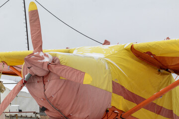 small aircraft with a propeller painted in bright colors in a case at the airfield or airport in...