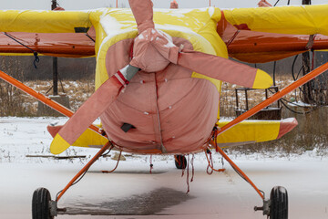 small aircraft with a propeller painted in bright colors in a case at the airfield or airport in...