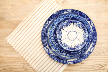 Fototapeta na wymiar Plates with a blue pattern, festive table setting. Close-up of the table set for dinner at home during the holiday season. Gzhel