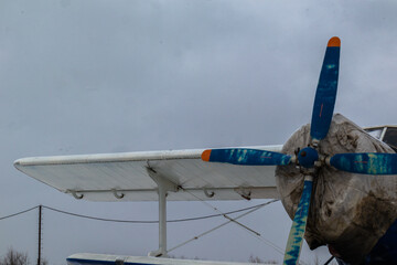 old, vintage plane with a small aircraft propeller at the airfield, airport in the snow in winter