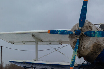 old, vintage plane with a small aircraft propeller at the airfield, airport in the snow in winter