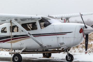 small aircraft with a propeller at the airfield, airport in the snow in winter