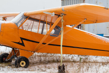 small aircraft orange at the airport, airport in the snow in winter