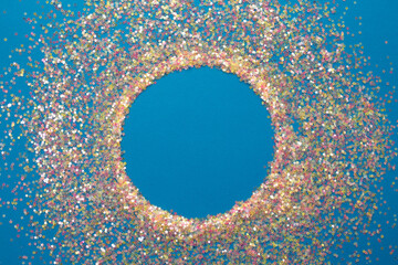 multicolored confetti on a blue background top view