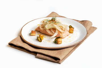 Salmon fillet cooked with aromatic herbs, lemon, garlic, olive oil, and a side of potatoes. White background - close-up.