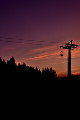 Ski chair lift in the mountains at beautiful sunset. Vertical photo.