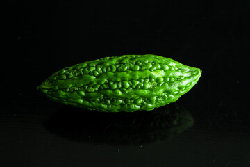 Green tropical momordica charantia or Chinese bitter gourd on black background