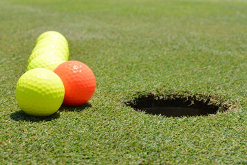 Perspective, Row, Seven Yellow, Orange Glowing Golf Balls, Hole, Green Grass, Field, Unique, Different, Stand Out, Competition, Bright, Leader, Leadership, Asia Pacific