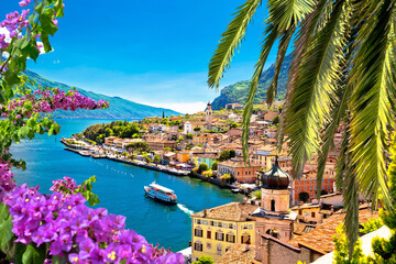 Limone sul Garda waterfront viewthrough flowers and palm tree - obrazy, fototapety, plakaty