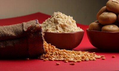 in bowl  Besan sweet Laddu or laddoo along with Chick pea flour or powder and split Bengal gram lentil.