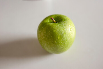 a green apple with drops of water