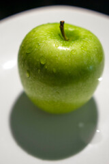 a green apple with drops of water