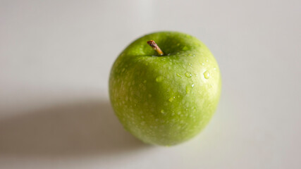 a green apple with drops of water