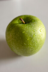 a green apple with drops of water