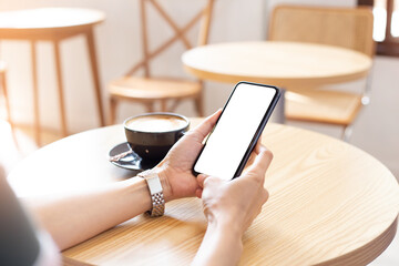 cell phone blank white screen mockup.woman hand holding texting using mobile on desk at coffee shop.background empty space for advertise.work people contact marketing business,technology