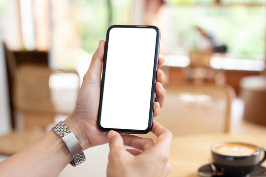 cell phone blank white screen mockup.woman hand holding texting using mobile on desk at coffee shop.background empty space for advertise.work people contact marketing business,technology