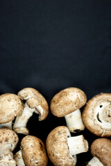 Top shot of fresh raw mushrooms on black background. 