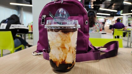 Chocolate milkshake in a glass placed on the table.