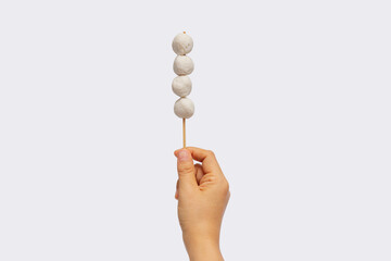 Female hand holding meat ball stick isolated on white background
