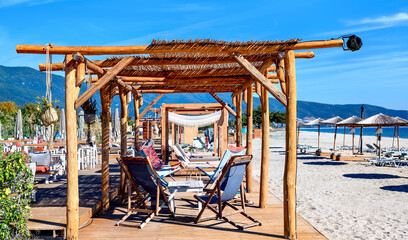 Reed umbrellas and sun beds with lounge tables