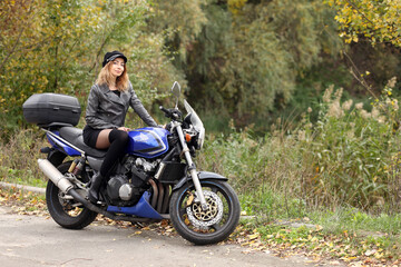 Obraz na płótnie Canvas Beautiful slim woman sitting on the motorcycle