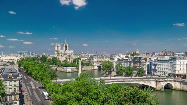 Paris Panorama with Cite Island and Cathedral Notre Dame de Paris on the background timelapse from the Arab World Institute observation deck. Top view. Green trees, Seine river, Blue cloudy sky at