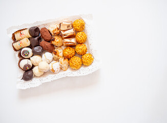 Assortment of pastries and sweets in a tray for dessert or tea time. Typical catalan food for autumn called Panellets. Flat lay with copy space