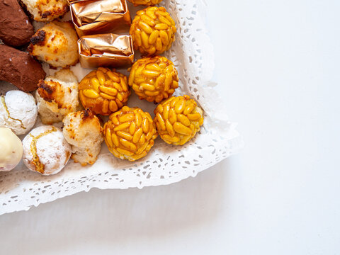 Close up of different pastries and sweets in a tray for dessert or tea time. Typical catalan food for autumn called Panellets. Flat lay with copy space