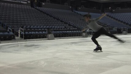 male figure skater performing a double axel jump in slow motion.