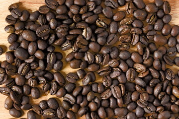Top down view of spread coffee beans on wooden table. Concept of coffee culture.