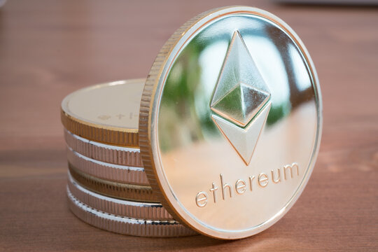 Pile of Coin of Silver Ethereum on wooden background