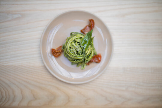 Above view of a zucchini noodles and spinach dish on a wooden table