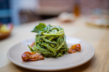 Zucchini noodles dish on a wooden table with a blurry background