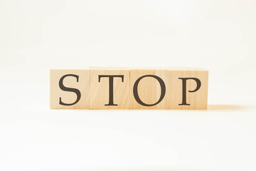 Stop word on wooden cubes with white background. Large letters.