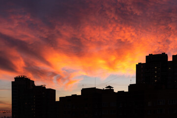 Fototapeta na wymiar Scenic vivid sunset over city buildings silhouette
