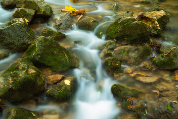 Fototapeta na wymiar The stream of water in the river flowing between the rocks , long exposure photo